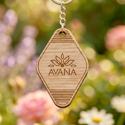 Close-up of laser engraved wooden keychain showing custom name and logo detail